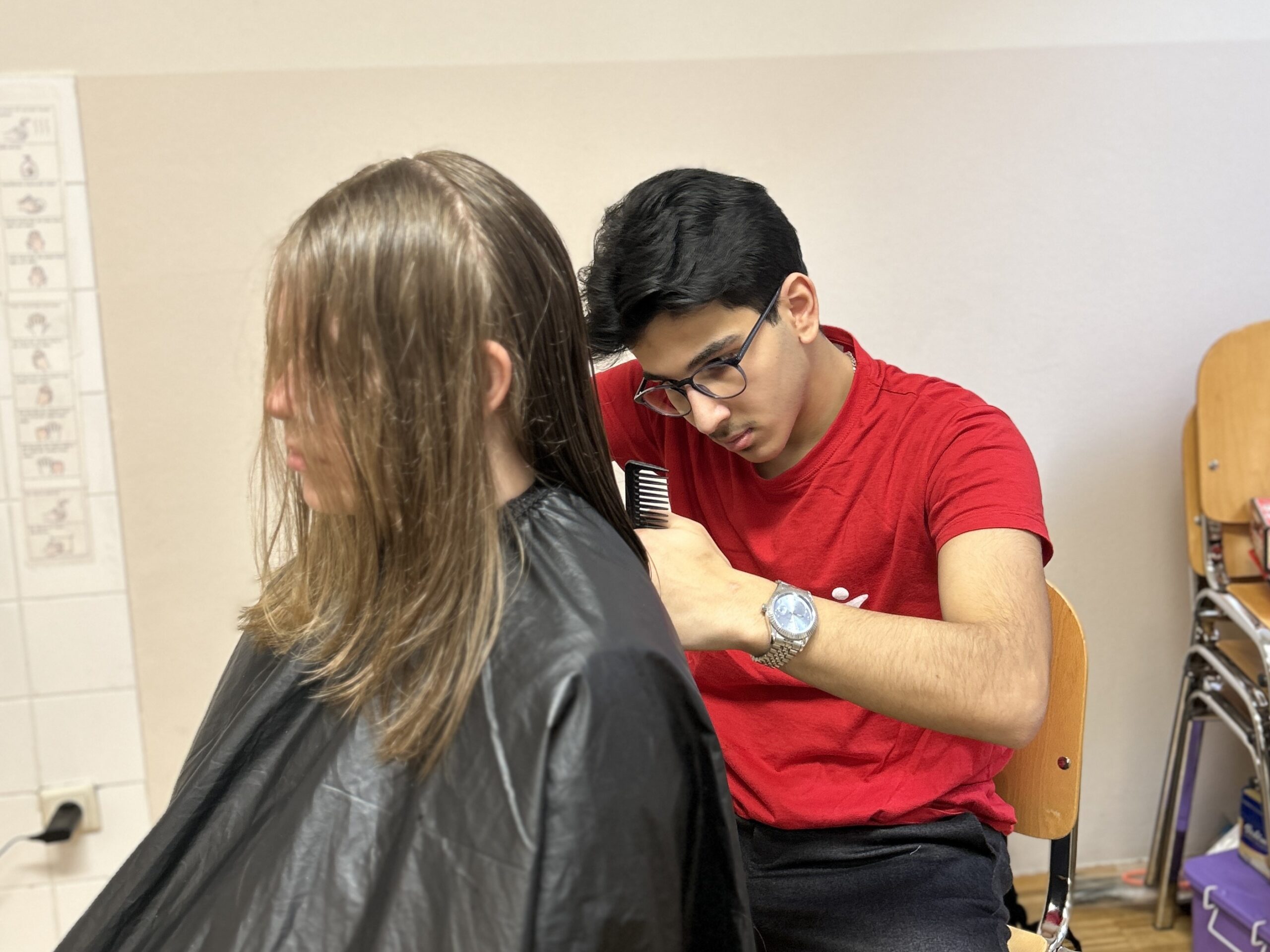 Mohammad Abdulfatah beim Haare schneiden einer Kundin
