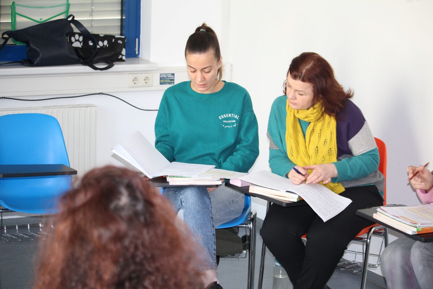 Diana und Nataliia lesen gemeinsam in ihren Deutsch Lernunterlagen
