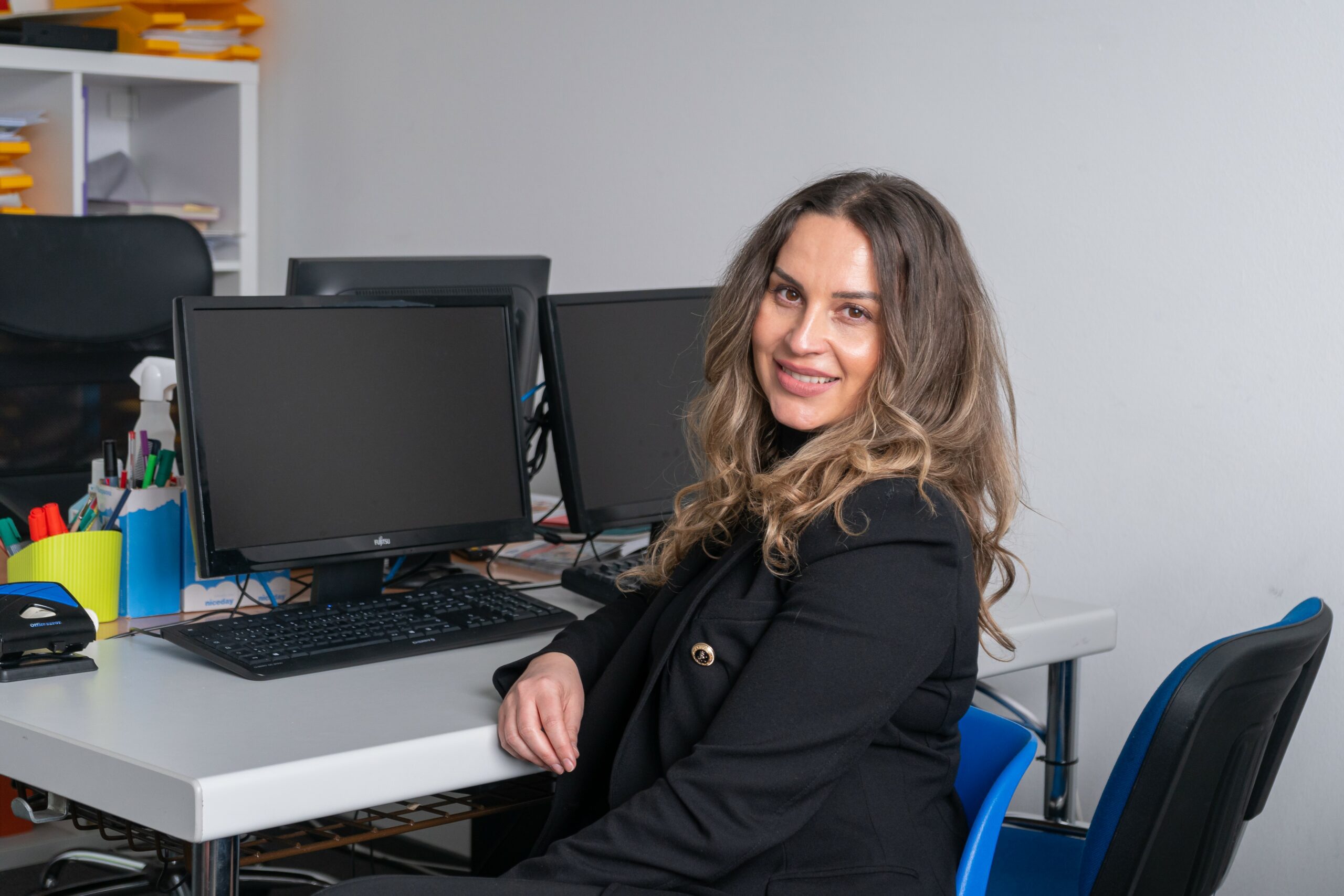 Kursteilnehmerin Alena Simankova sitzt an einem Computertisch und lächelt in die Kamera