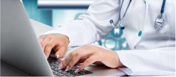 Eine Mitarbeiterin aus dem medizinischen Fachbereich schreibt auf einem Laptop ein Protokoll