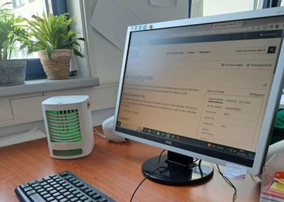 Monitor neben dem ein Tischklimagerät steht
