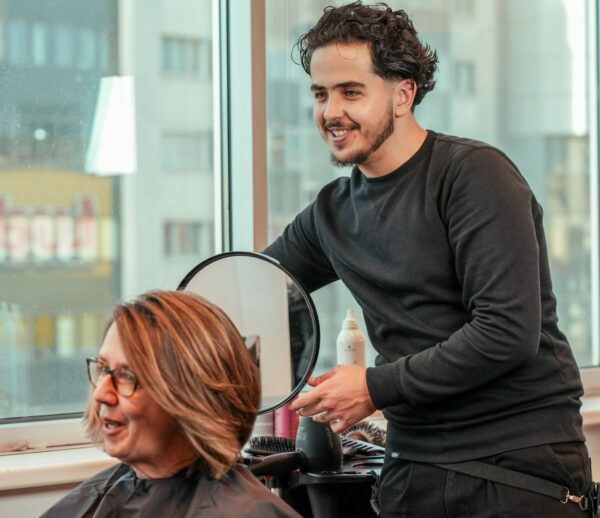 Friseur präsentiert fertigen Haarschnitt