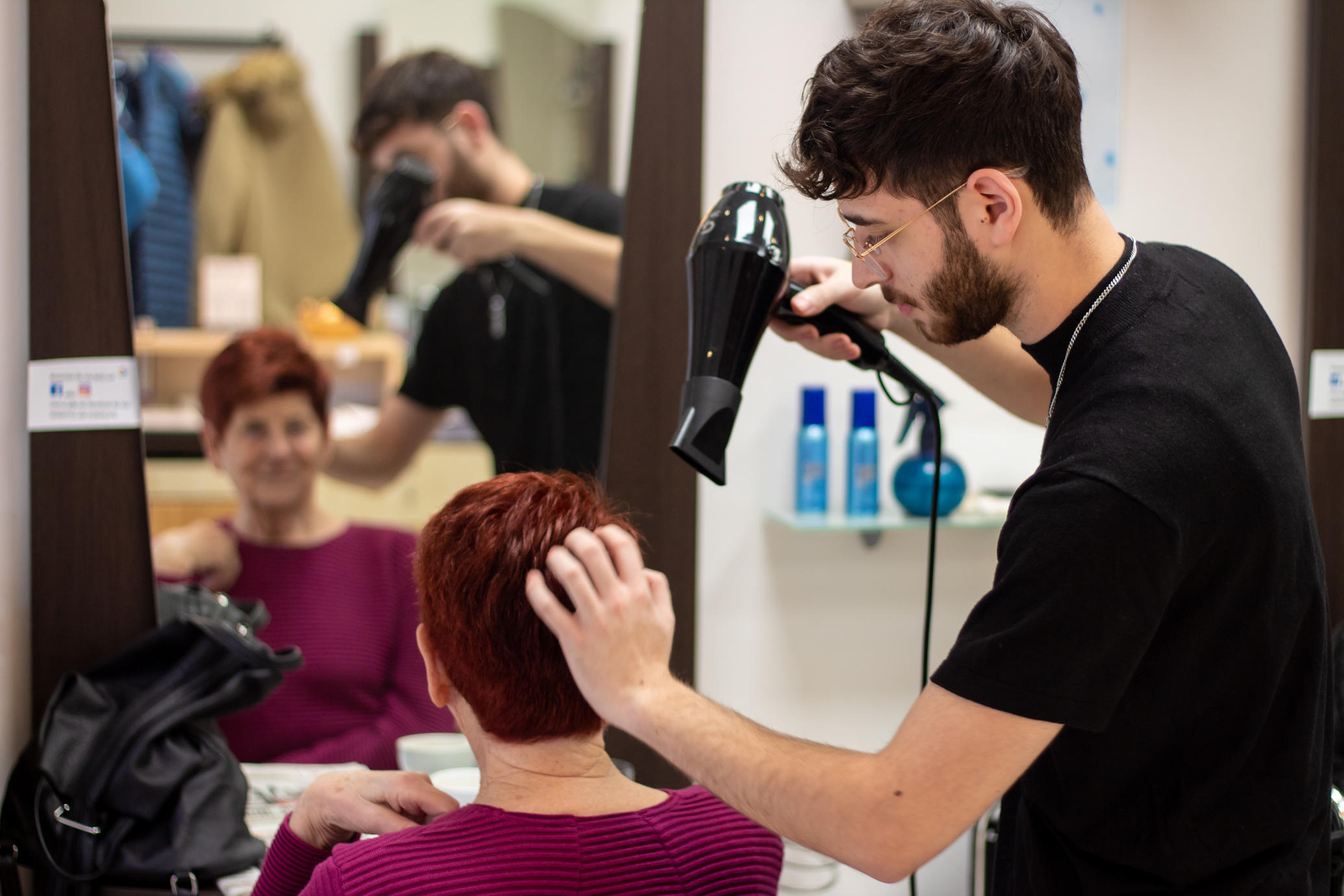 Friseurlehrling beim Föhnen