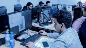 Person sitzt vor einem Computer Monitor