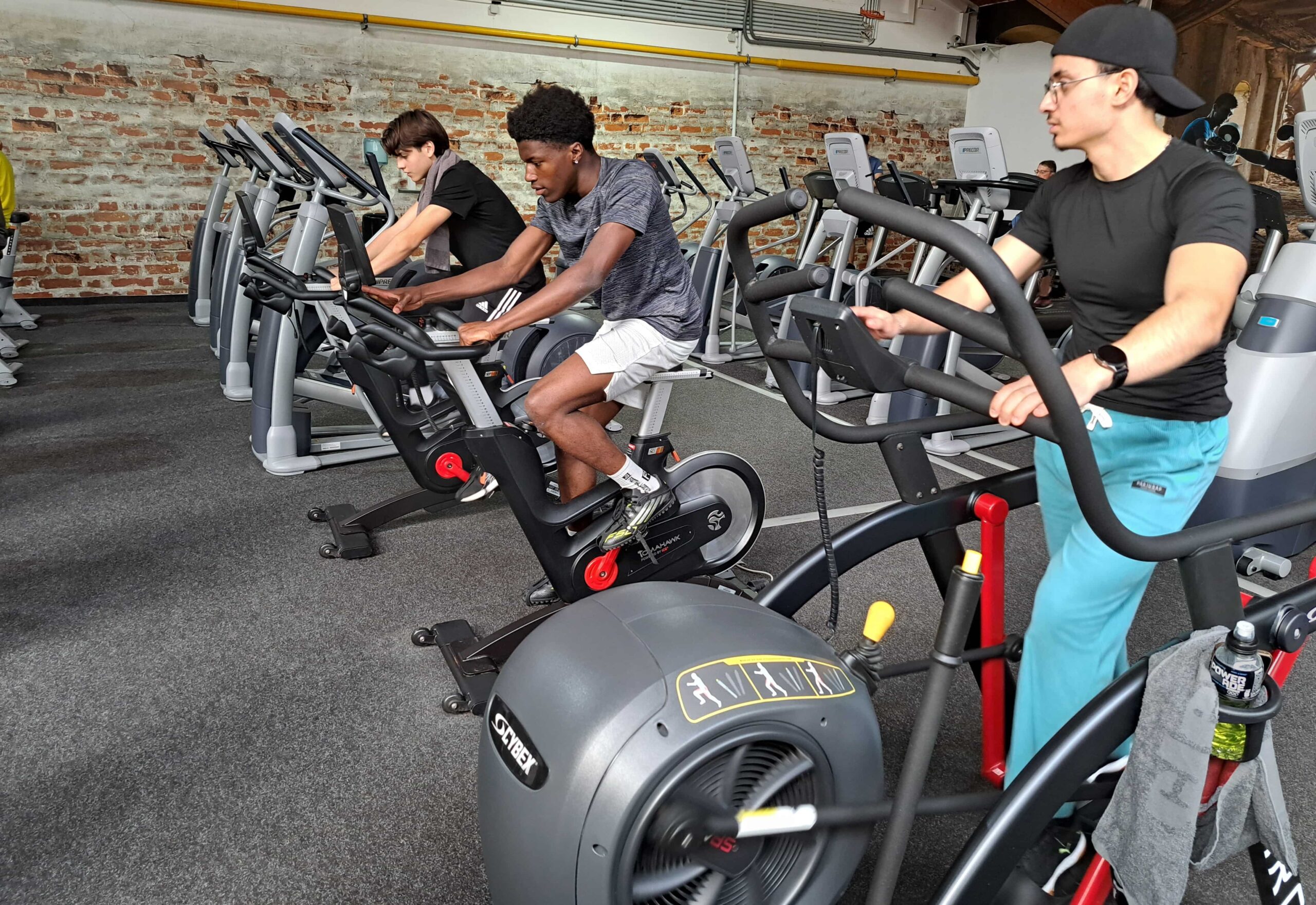 Lehrlinge der ÜBA Fitnessbetreuung im Fitnessstudio auf Indoor Bikes