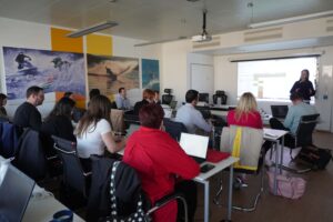 Partner:innen des PATHS Projekts von hinten beim Mitschreiben während einer Präsentation