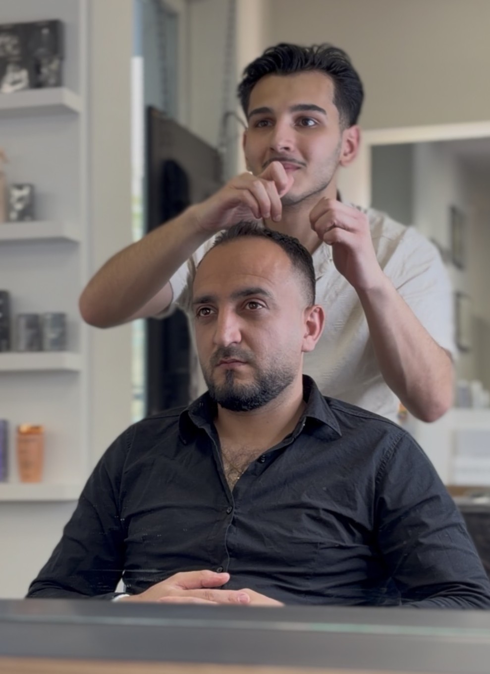 Mohammad Abdulfatah beim Haare schneiden eines Kundens